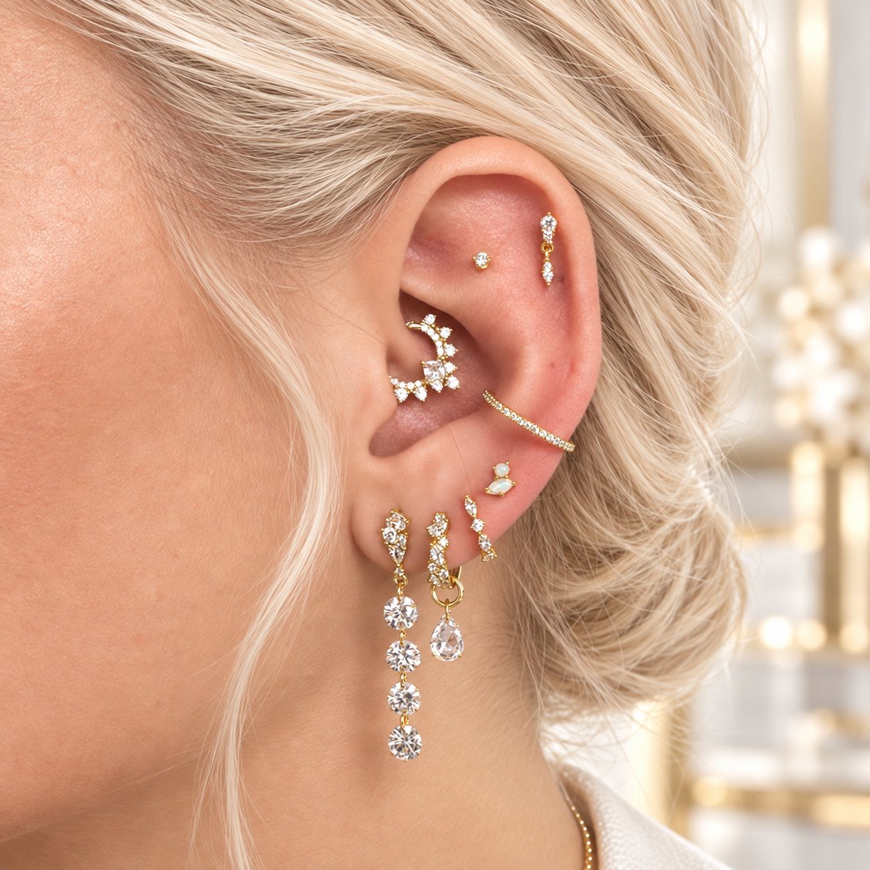 Gold ear stack with a flat stud, daith hoop, conch hoop and lobe drops