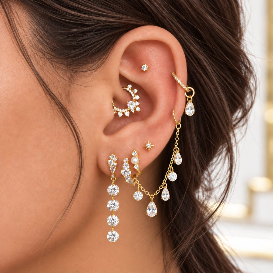 Gold ear stack: flat stud, helix hoop with a drop, daith hoop, star stud, pearl hoop and chain